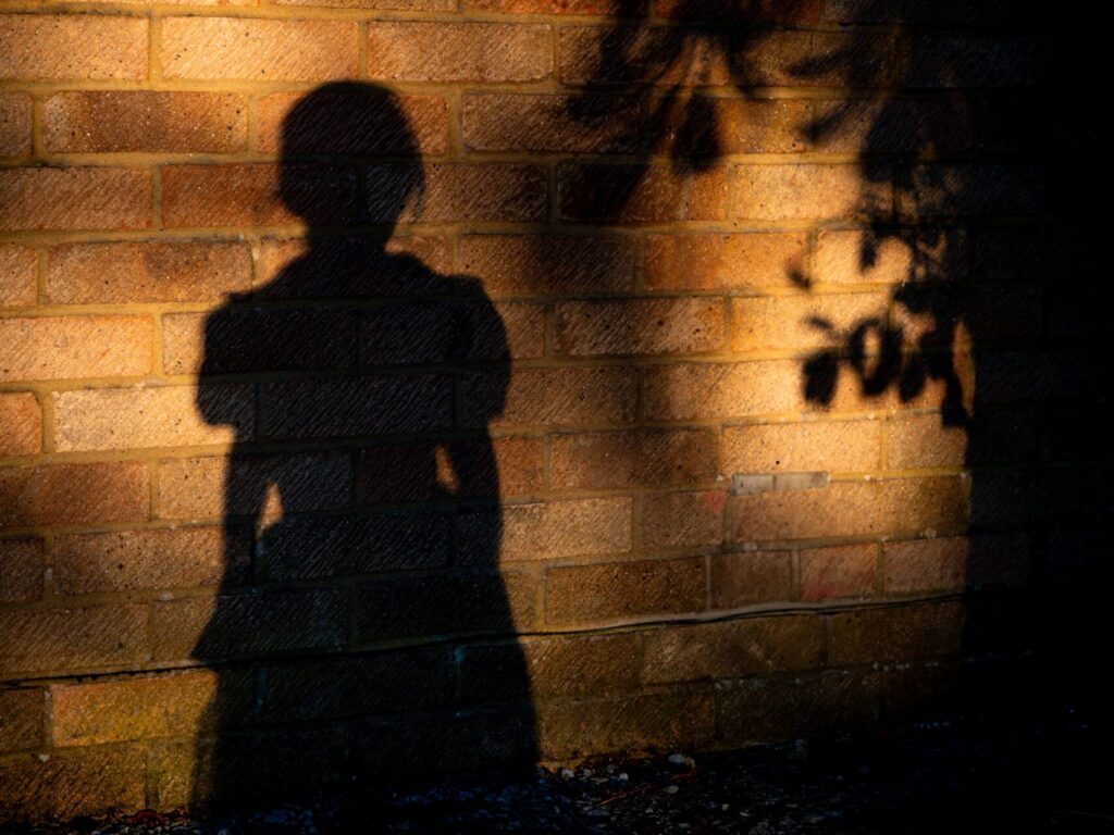 A play of light and shadow: The silhouette of a person on a wall bathed in warm light